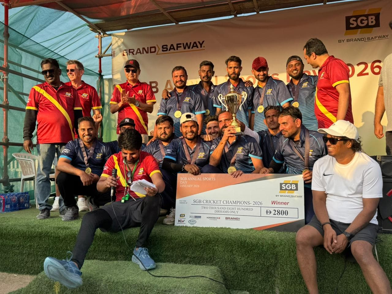 A winning team celebrating with the trophy at a MAX Sports tournament